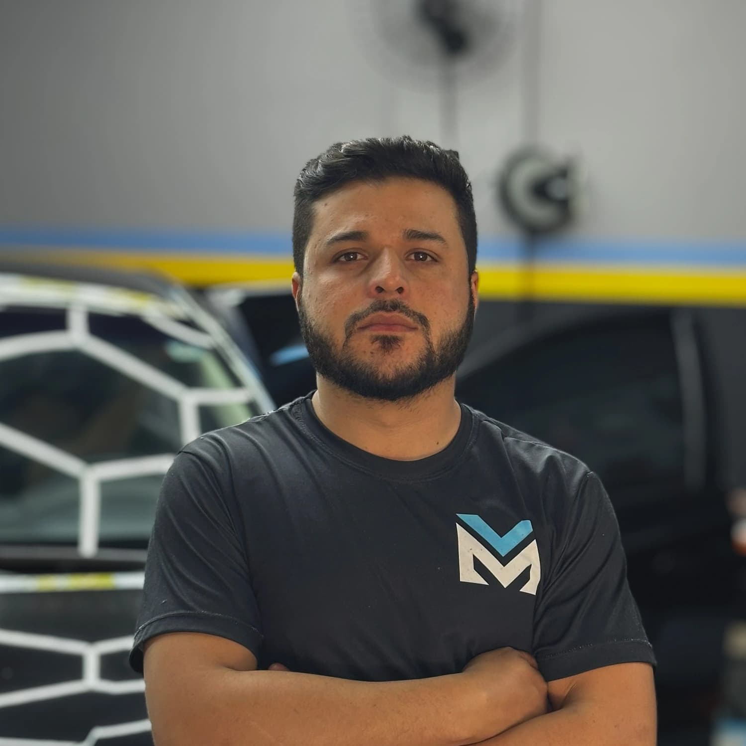 Dono da MV Estética Automotiva de braços cruzados no salão da oficina