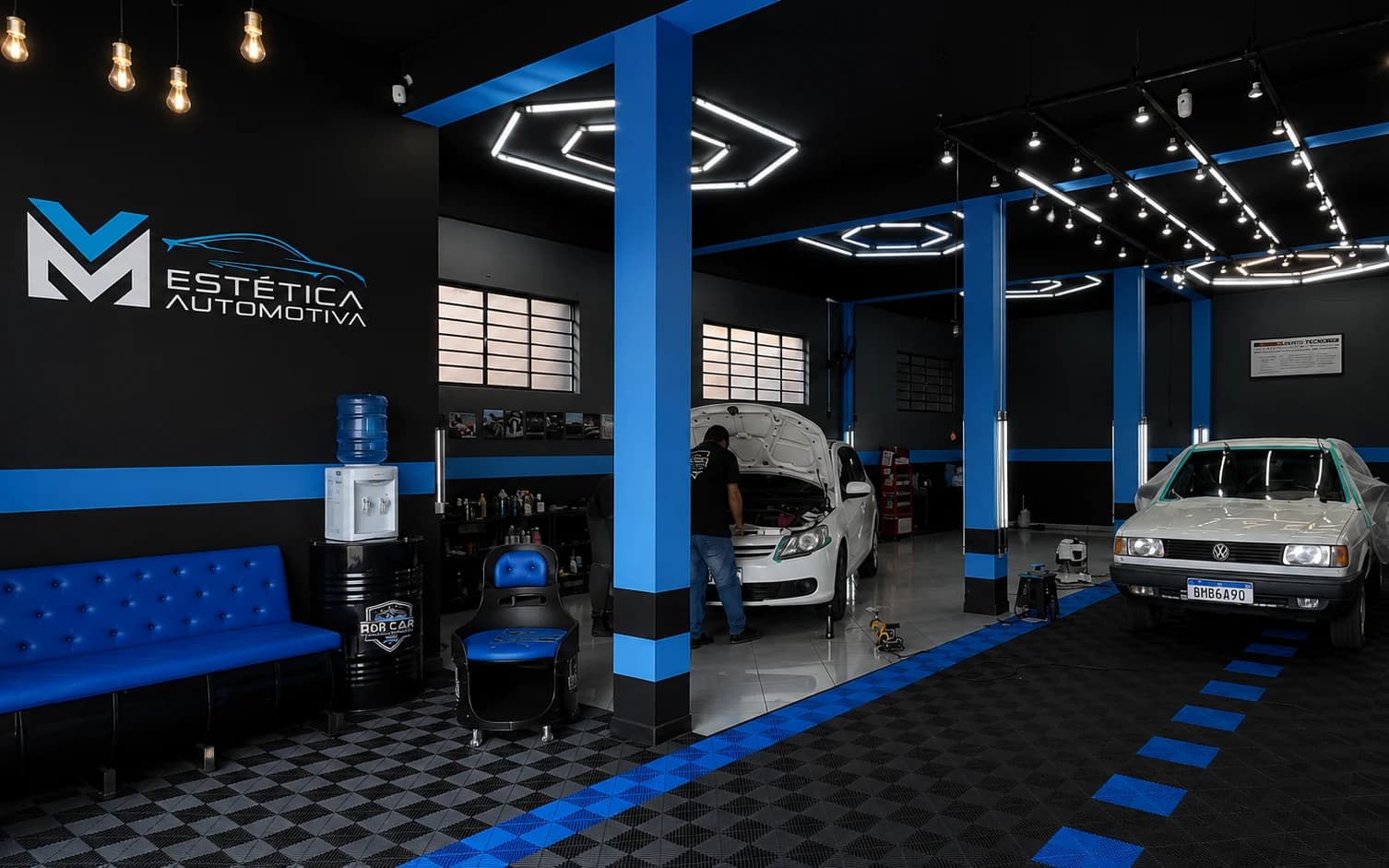 Salão da MV Estética Automotiva com a marca na parede e veículos em atendimento
